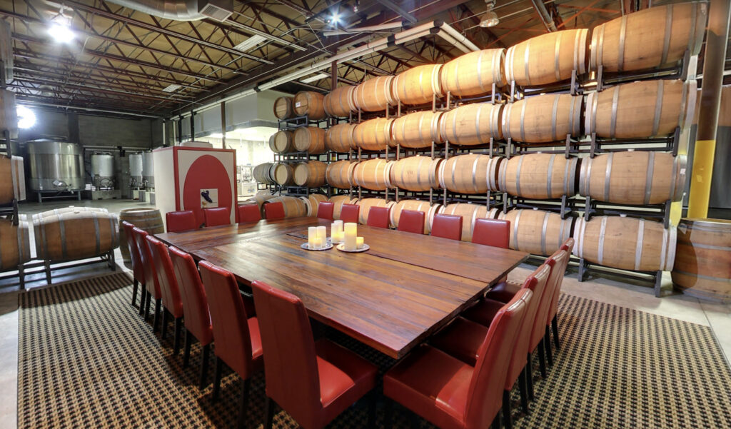 Industrial private dining and tasting room with exposed wine barrels 